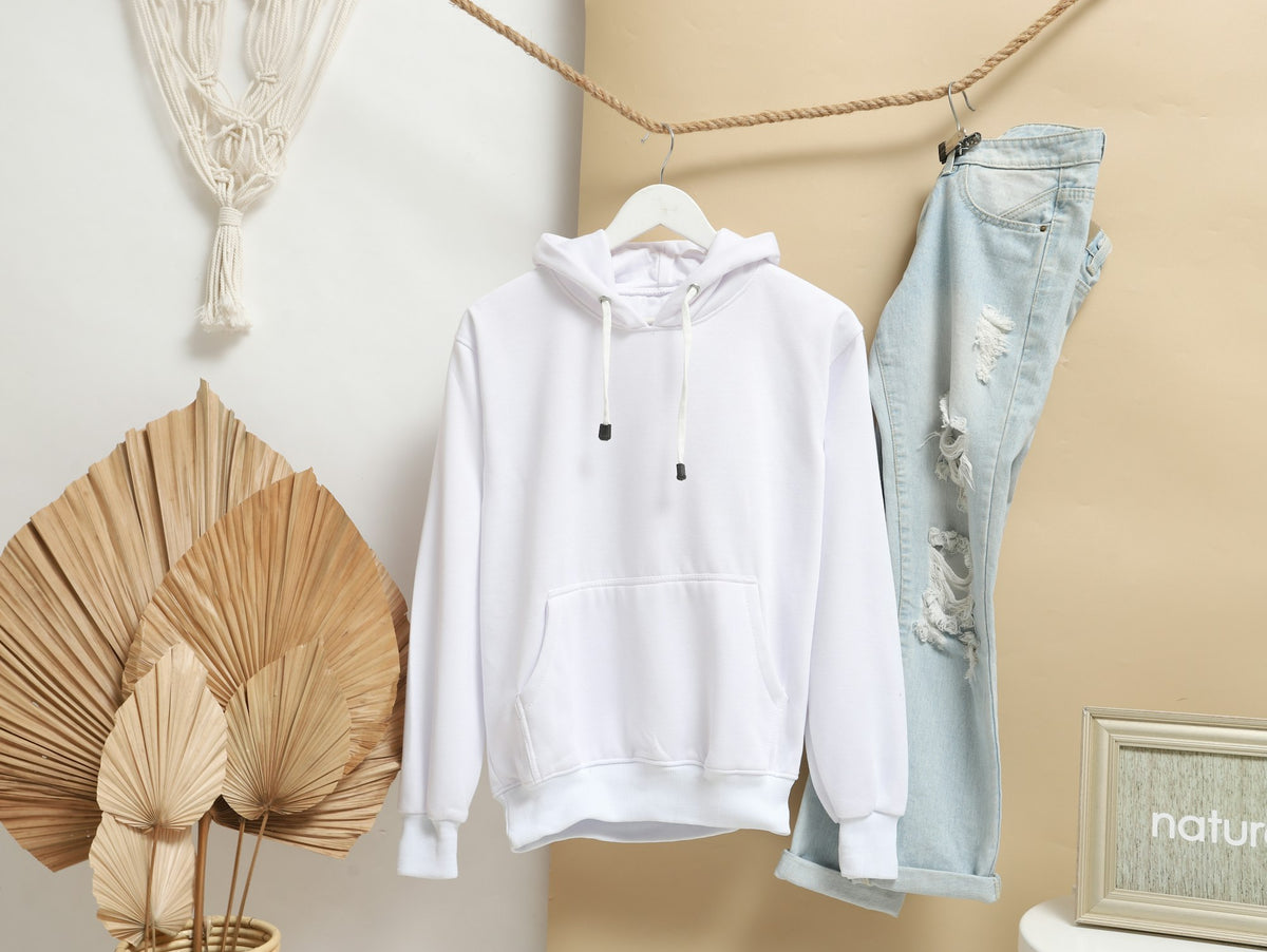 A clean white hoodie hanging on a wooden hanger, minimal and considered