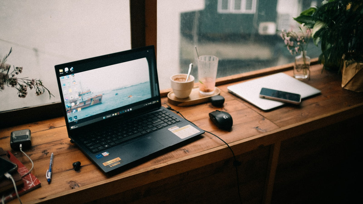 Laptop on a warm wooden café table, soft tungsten light