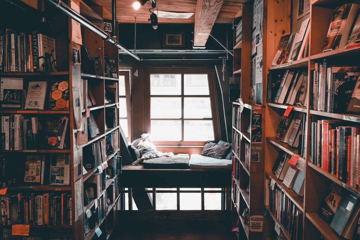 Warm library interior with wooden bookshelves and ambient lighting