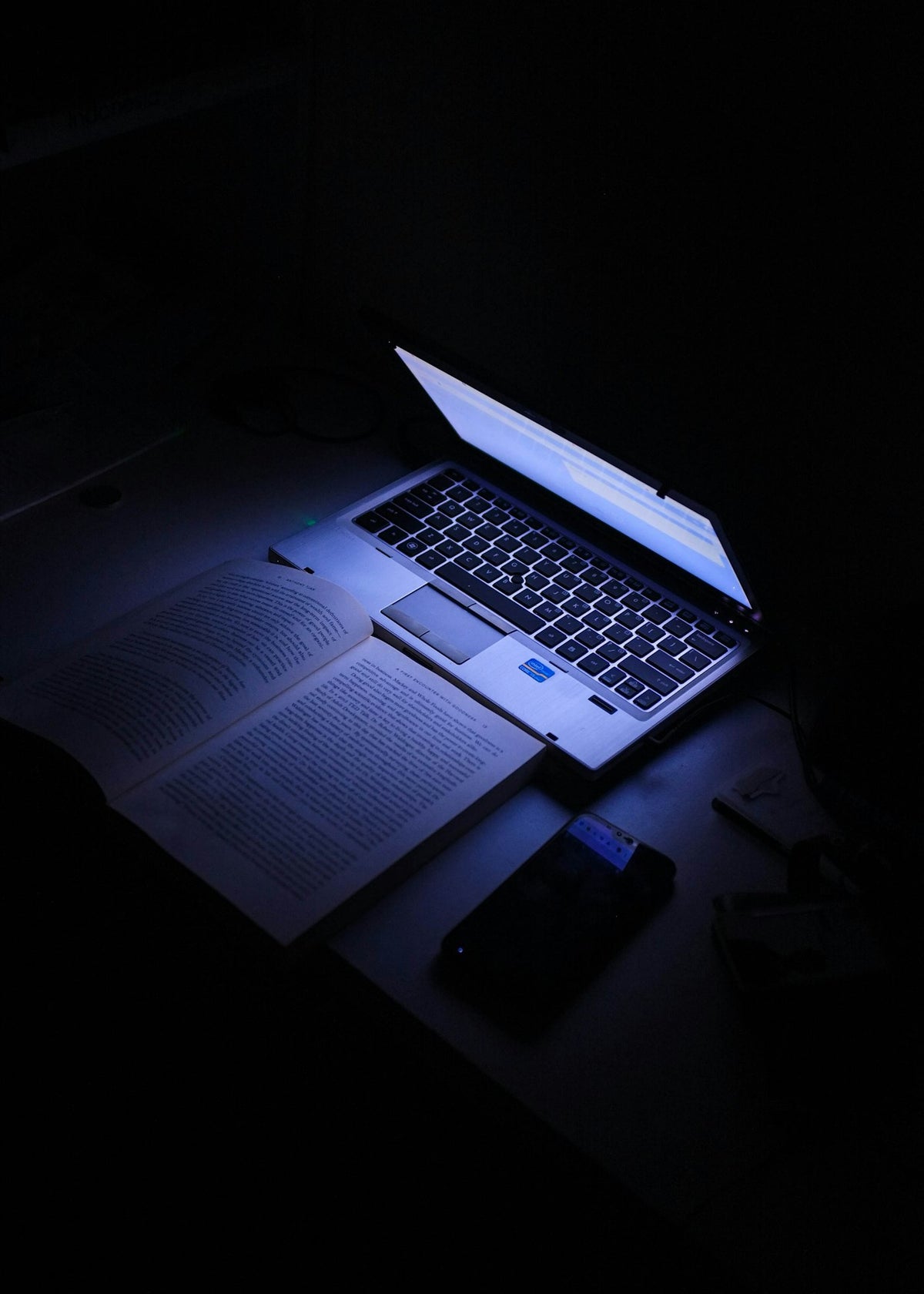 Laptop glowing in a dark room during a late-night exam season study session