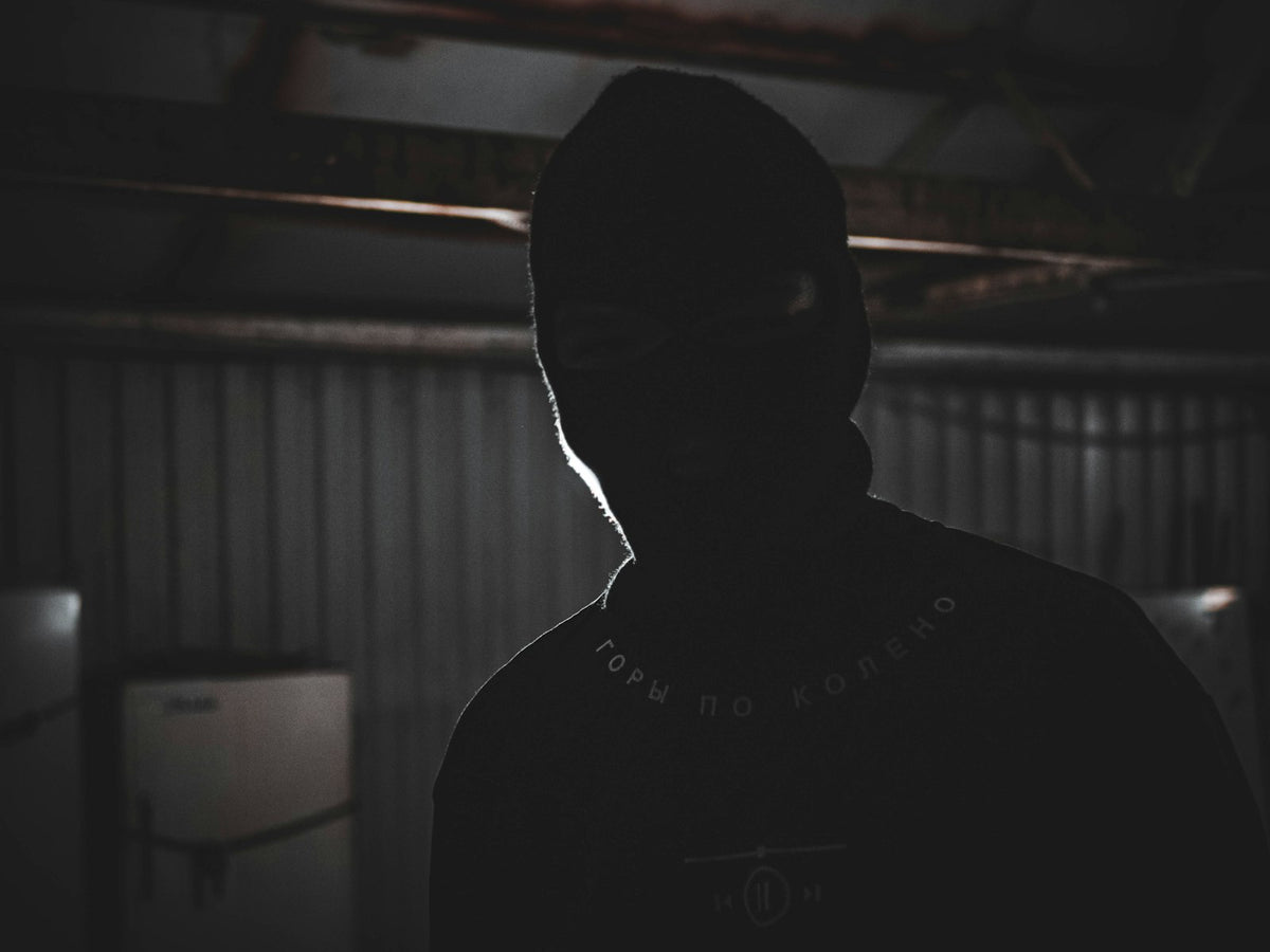 A person in an oversized hoodie standing in a dimly lit room